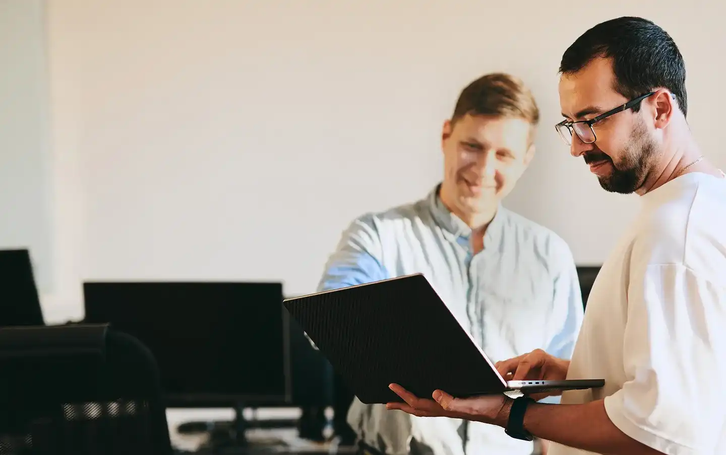 Two IT professionals collaborating at a computer on a modern technology project, illustrating IT strategy consulting services built for planning scalable software solutions.